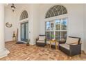 Cozy front porch with seating area, brick-paved floor, and decorative arched windows at 10724 Cory Lake Dr, Tampa, FL 33647