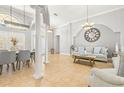 Open-concept living and dining area with tile floors, elegant columns, and lots of natural light at 10724 Cory Lake Dr, Tampa, FL 33647