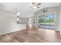 Open-concept living space boasts wood-look floors, a vaulted ceiling, and seamless access to the outdoor screened patio at 11225 Flower Ave, Weeki Wachee, FL 34613