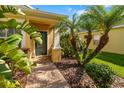 Close-up of the home's entrance featuring a brick pathway, lush landscaping, and a welcoming, freshly-painted front door at 11813 Crawford Parrish Ln, Parrish, FL 34219