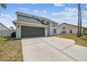Two-story home featuring a two-car garage and large driveway with space for multiple vehicles at 12102 Steppingstone Blvd, Tampa, FL 33635