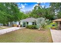 Charming light-blue home with well-manicured lawn, stone pathway, and inviting front porch area at 1213 E Idlewild Ave, Tampa, FL 33604