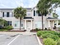 Beige townhome featuring dark shutters and palm trees enhancing curb appeal at 12268 Country White Cir, Tampa, FL 33635