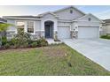 Charming single-Gathering home with a three-car garage, stone accents and tidy landscaping at 13014 Willow Grove Dr, Riverview, FL 33579