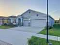 Charming single-Gathering home with a three-car garage, stone accents, and well-maintained landscaping at 13014 Willow Grove Dr, Riverview, FL 33579
