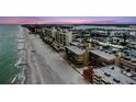 Aerial view of condo building, beach and ocean in an attractive coastal setting at 14900 Gulf Blvd # 308, Madeira Beach, FL 33708