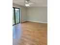 Bright living room featuring wood floors, a ceiling fan, and large sliding glass doors at 1515 Bayshore Blvd # 38, Dunedin, FL 34698