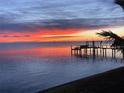 Picturesque sunrise view over the water with a silhouette of a private dock in the foreground at 1967 Brightwaters Ne Blvd, St Petersburg, FL 33704