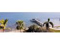 Beautiful waterfront view featuring a private wooden dock surrounded by lush palm trees at 1967 Brightwaters Ne Blvd, St Petersburg, FL 33704