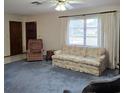 Inviting living room featuring neutral walls, plush blue carpet, and lots of natural light at 2226 Giralda Ave, Spring Hill, FL 34606