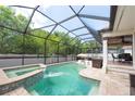 Inviting screened pool and spa area with lush landscaping and covered patio for outdoor entertaining at 2969 La Concha Dr, Clearwater, FL 33762