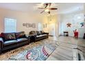 Bright living room with a ceiling fan, wood-look floors, and comfortable leather couches at 300 S Florida Ave # 600L, Tarpon Springs, FL 34689