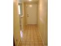 Hallway view featuring tile floors and a white entry door to the home at 3077 Casa Del Sol Cir # 207, Clearwater, FL 33761