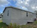 The side of the house is clad in gray siding, showing multiple windows, and a small set of stairs at 3221 Roxborough Ave, Clearwater, FL 33762