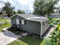 View of home featuring neutral siding, new roof, and meticulously manicured landscaping at 37045 North Ave, Dade City, FL 33523