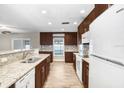 Bright kitchen featuring granite countertops, stainless steel appliances, wood-look flooring, and ample cabinet space at 3917 Casaba Loop, Valrico, FL 33596