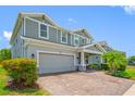 Two-story home showcasing a manicured lawn and a two-car garage with a brick paved driveway at 4633 Ballantrae Blvd, Land O Lakes, FL 34638