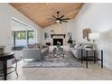 Bright living room with vaulted wood ceiling, fireplace, and sliding glass doors to the pool area at 4706 Fox Hunt Dr, Tampa, FL 33624