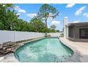 Refreshing pool with rock feature, surrounded by a white fence and a screened-in porch at 4706 Fox Hunt Dr, Tampa, FL 33624