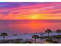 Scenic view of a beach sunset with vibrant colors and palm trees along the shore at 503, 509, Cottage, Land 69Th Ave, St Pete Beach, FL 33706