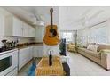 Bright kitchen with white cabinets, stainless appliances, and adjacent living area at 503, 509, Cottage, Land 69Th Ave, St Pete Beach, FL 33706