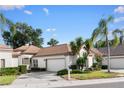 Charming single-story home featuring a well-manicured lawn, mature trees, and a two-car garage at 5117 Fairway One Dr, Valrico, FL 33596