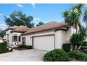 A well-kept home featuring an attached two-car garage and well-manicured landscaping at 5117 Fairway One Dr, Valrico, FL 33596