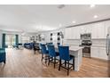 Open-concept kitchen features white cabinetry, a center island with barstool seating, and stainless-steel appliances at 5511 Badini Way, Palmetto, FL 34221