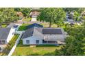 Backyard of home featuring solar panels, screened-in porch and a spacious green lawn at 5808 Silver Moon Ave, Tampa, FL 33625