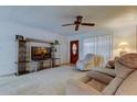 Bright living room with plush carpeting, fan, and a large entertainment center at 6409 41St N Ave, St Petersburg, FL 33709