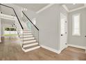 Bright entryway featuring hardwood floors, a modern staircase with glass railings, and natural light at 710 E Plymouth St, Tampa, FL 33603