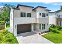Contemporary home with stone accents, a modern garage door, and manicured landscaping at 710 W Plymouth St, Tampa, FL 33603