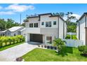 Stunning two-story home featuring a modern design, lush landscaping, and a sleek garage door at 710 W Plymouth St, Tampa, FL 33603