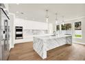 Modern kitchen featuring a large marble island, stainless steel appliances, and custom white cabinets at 710 W Plymouth St, Tampa, FL 33603