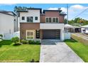 Modern two-story home featuring a well-manicured lawn and a stylish brown and white exterior at 712 W Plymouth St, Tampa, FL 33603