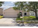 Inviting one-story home with a lush lawn, convenient two-car garage, and charming curb appeal at 7157 Hamilton Park Blvd, Tampa, FL 33615