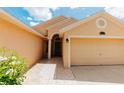 Close up of home's entrance featuring tiled walkway, covered entry, and attached two-car garage at 9852 Laurel Ledge Dr, Riverview, FL 33569