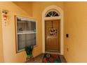 Inviting front entryway with a decorative wreath, tiled floor, and vibrant flower pot at 9852 Laurel Ledge Dr, Riverview, FL 33569
