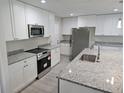Bright kitchen features white cabinets, stainless steel appliances, granite countertops, and an island with a sink at 11210 Mcmullen Rd, Riverview, FL 33569
