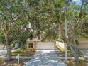 Single-Gathering home featuring mature shade trees, a well-maintained lawn, and a two-car garage at 11627 Ivy Flower Loop, Riverview, FL 33578