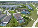 An aerial view of a home with a screened pool surrounded by lush greenery in a residential neighborhood at 11904 Greenchop Pl, Riverview, FL 33579