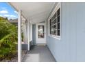 A covered entryway featuring a modern white door and gray concrete at 1205 Desert Hills Dr, Sun City Center, FL 33573