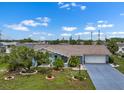 Charming blue home featuring a well-manicured lawn and a long driveway at 1205 Desert Hills Dr, Sun City Center, FL 33573