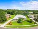 Gorgeous aerial view of home showcasing manicured lawn, mature landscaping and circular driveway situated among lush greenery at 13608 Lytton Way, Tampa, FL 33624