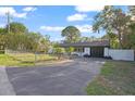 Single-story home featuring a well-maintained lawn, fenced yard, and two-car garage at 15025 Shark St, Hudson, FL 34667