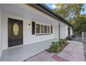 Inviting front porch with a modern door and updated brick accent wall, with tasteful landscaping at 15025 Shark St, Hudson, FL 34667