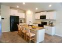Well-lit kitchen featuring an island with bar seating and white cabinetry at 15709 Demory Point Pl, Ruskin, FL 33573