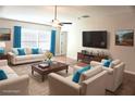 Bright living room with a ceiling fan, large windows, and modern furnishings at 15709 Demory Point Pl, Ruskin, FL 33573