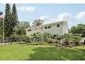 Beautiful two-story home showcasing meticulously landscaped grounds, lush greenery, and a well-manicured lawn at 1709 Main St, Safety Harbor, FL 34695