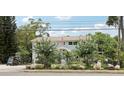 A charming two-story home with attractive landscaping, mature trees, and a view of a well-maintained front yard at 1709 Main St, Safety Harbor, FL 34695